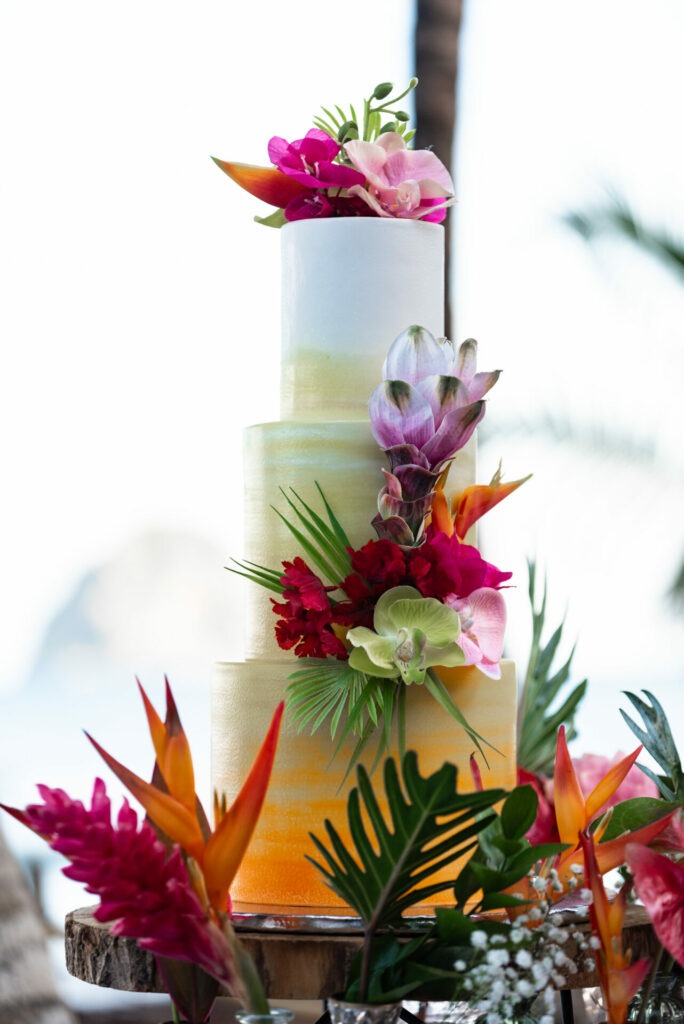 Tropical wedding cake decorated with fresh exotic flowers during a beach wedding in Martinique.
