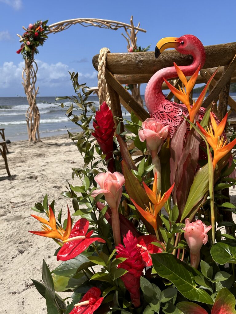 Détails de fleurs exotiques aux tons corail et feuillage pour mariage tropical chic